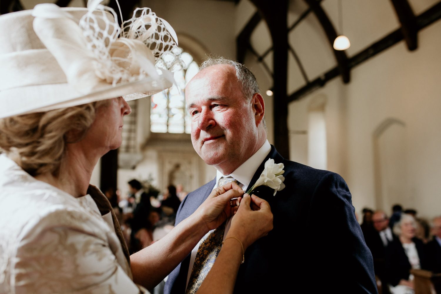 luxury manor house hotel wedding family of the bride and groom mother of the bride helps with flower lapel