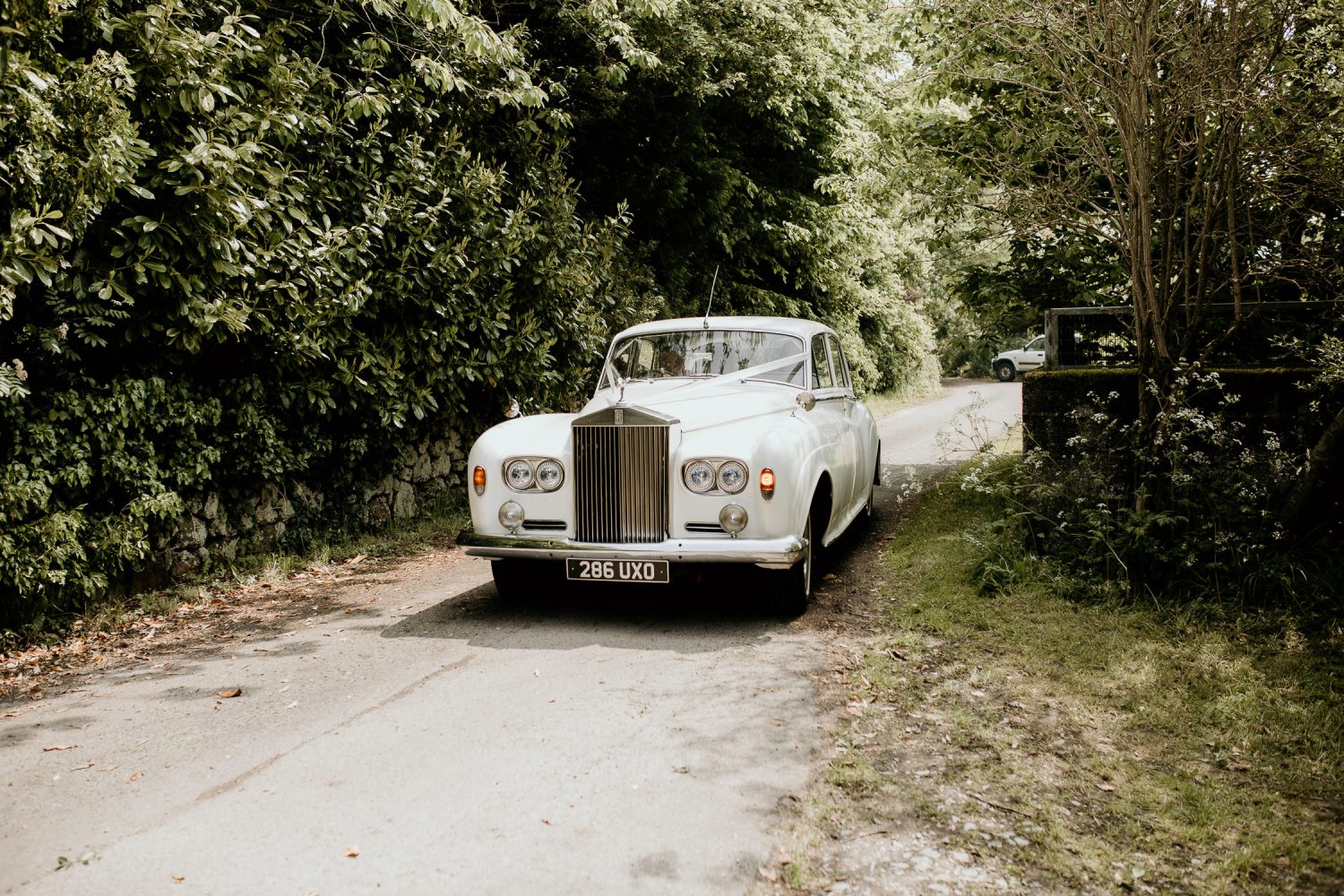 luxury manor house hotel wedding beautiful vintage white rolls royce in a sunny country lane