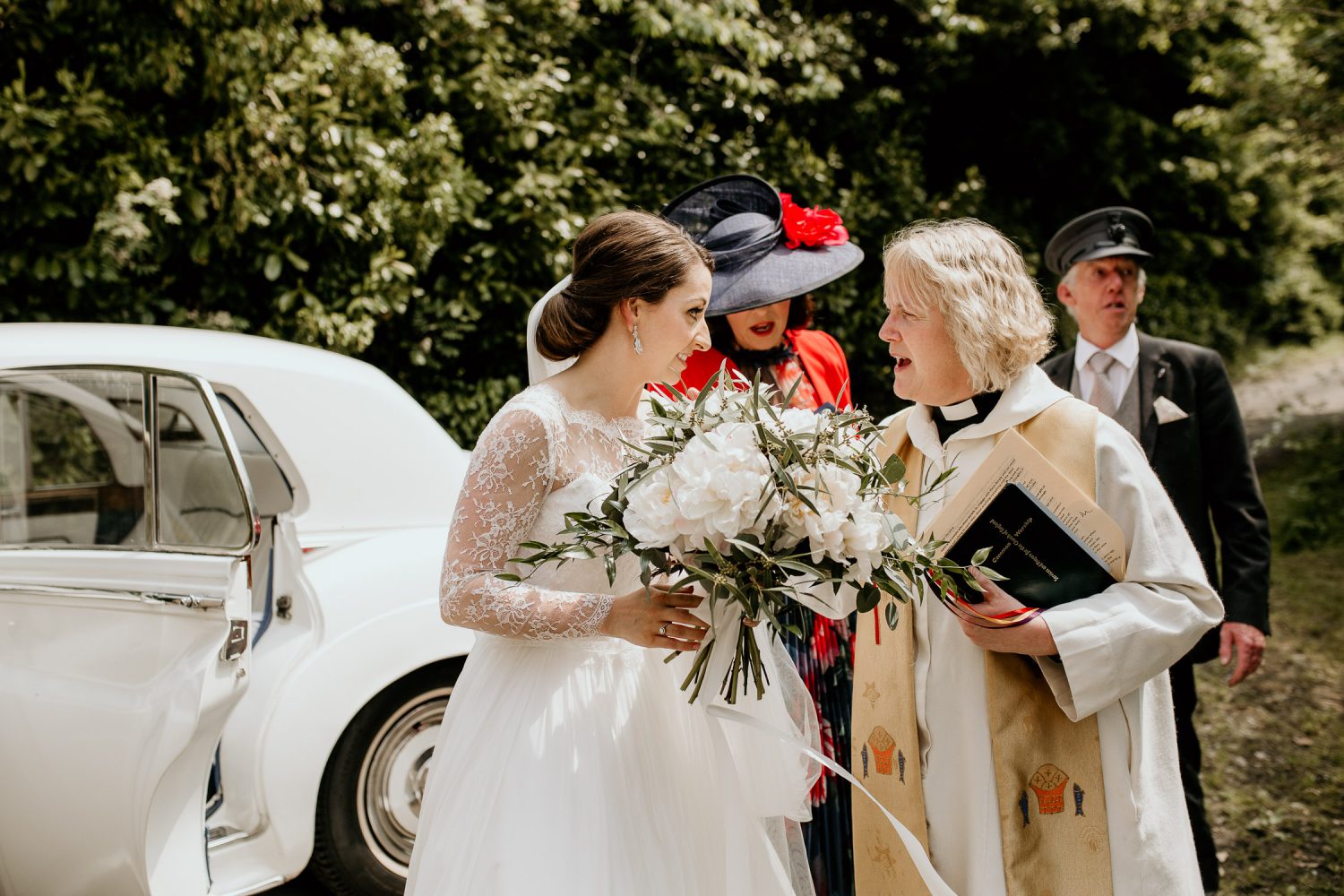 luxury manor house hotel wedding bride talks to the vicar before the ceremony