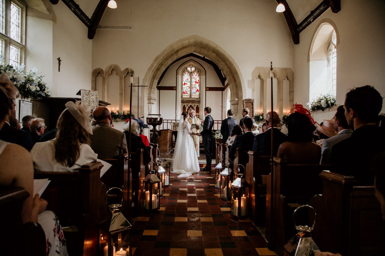 luxury manor house hotel wedding bride and groom hold hands as they take their vows with their guests watching on