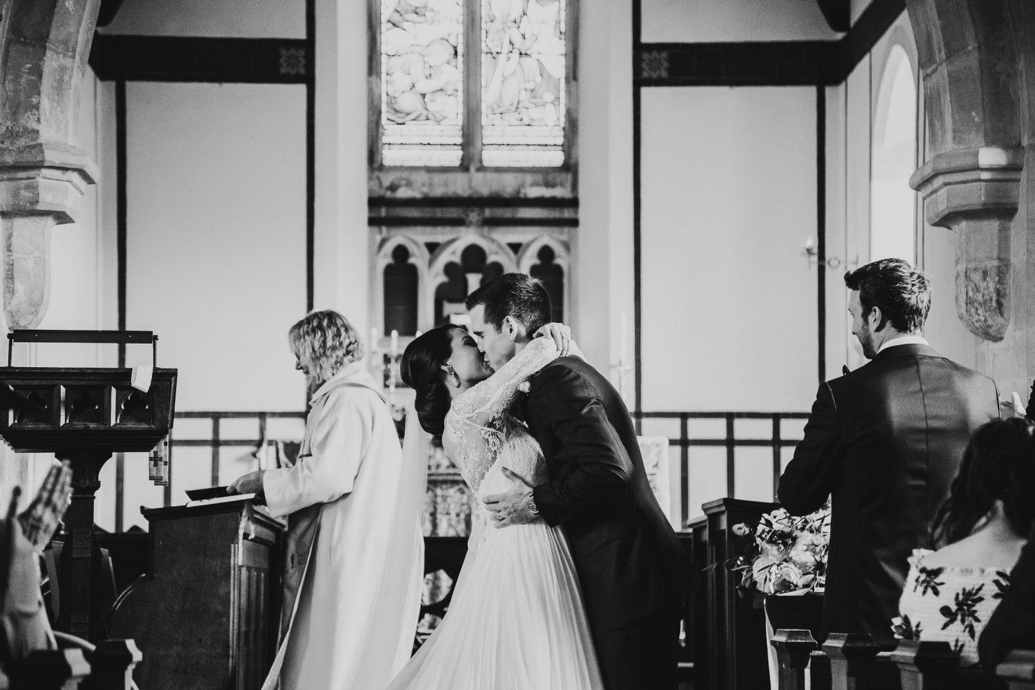 luxury manor house hotel wedding black and white photo of the bride and grooming kissing at the alter after taking their vows