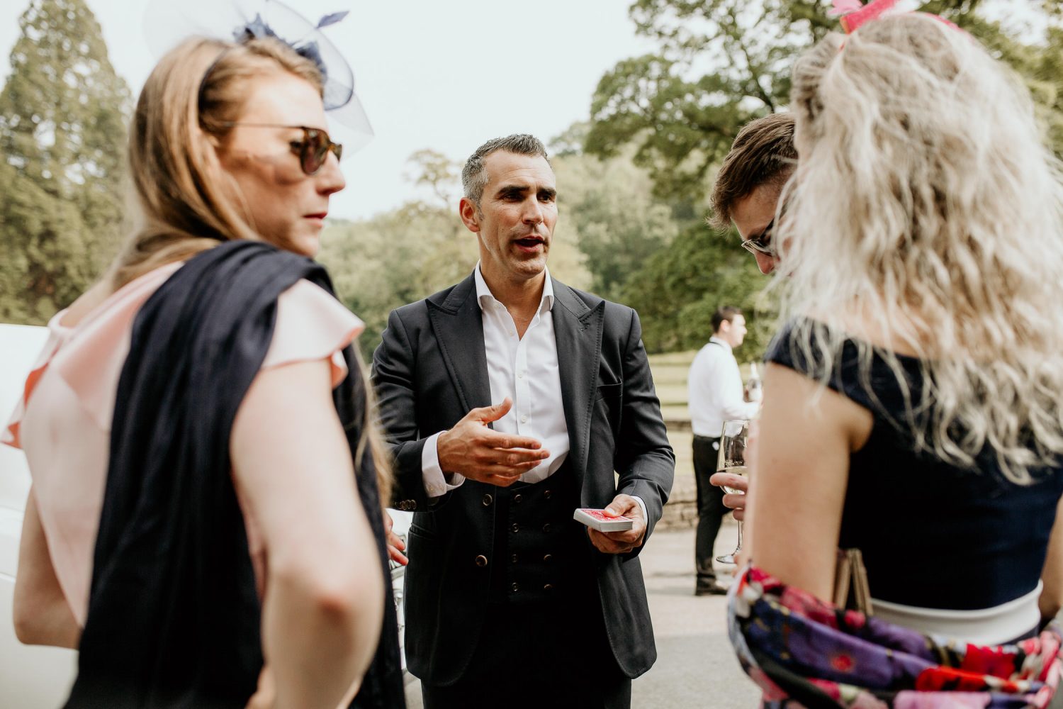 luxury manor house hotel wedding guests talking outside in the sunshine
