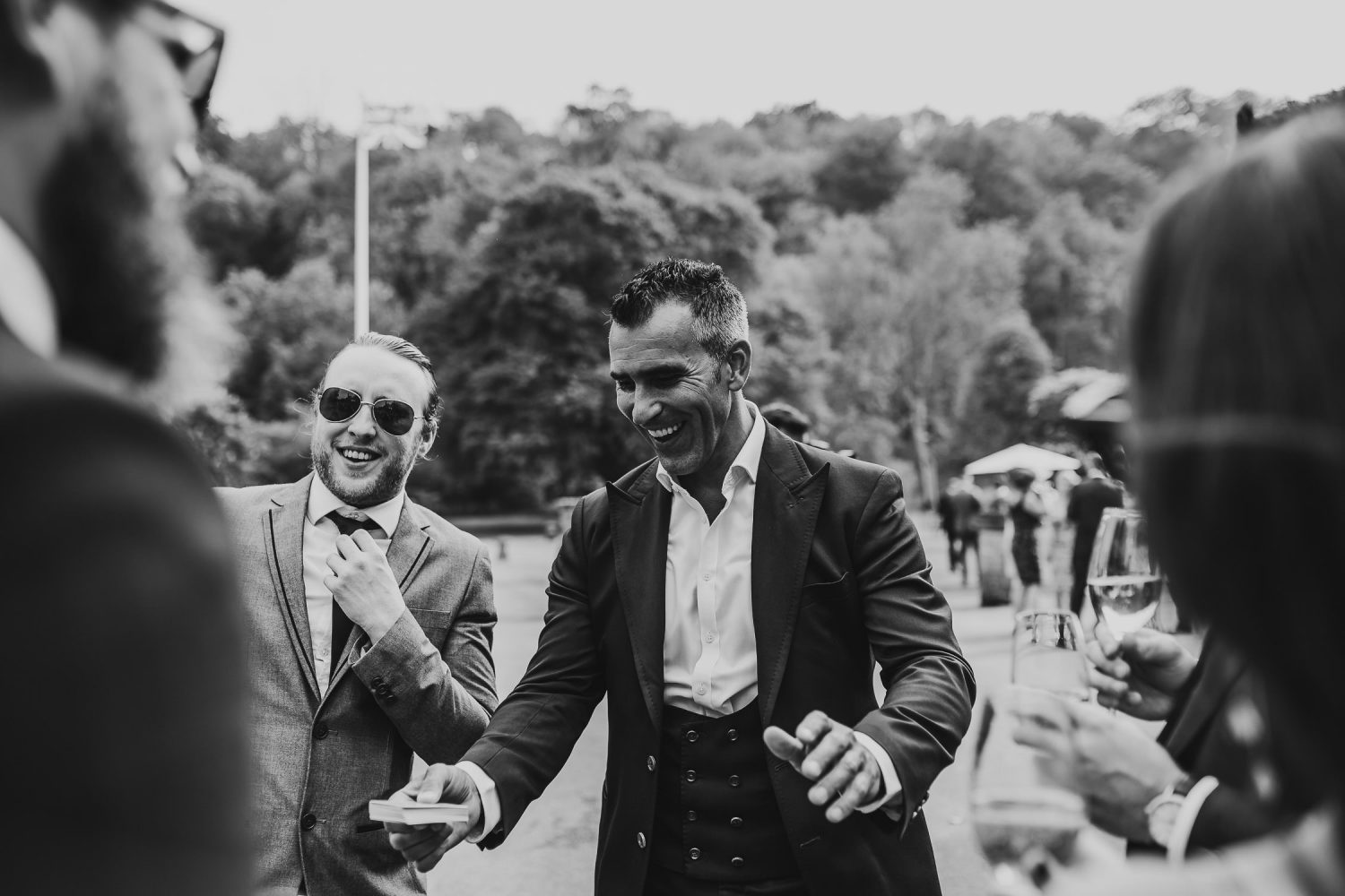 luxury manor house hotel wedding black and white shot of guests laughing outside venue