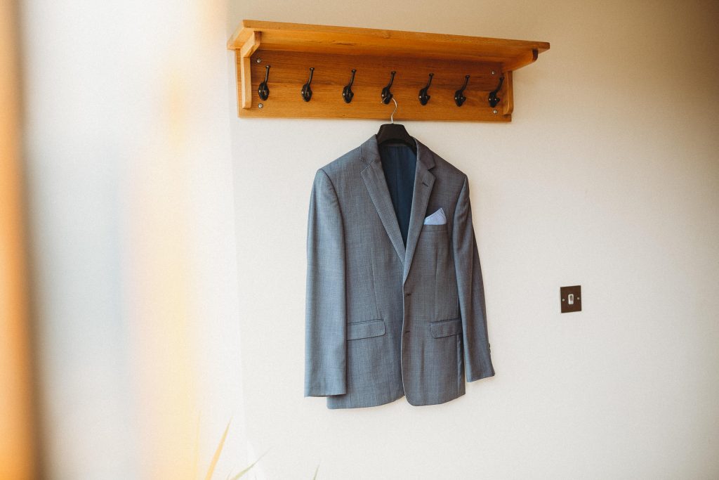 luxurious grey wedding jacket hung up on the morning of the wedding