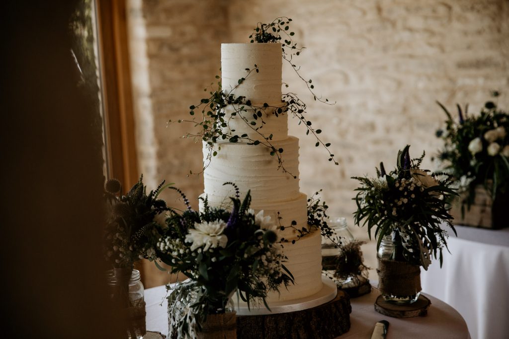 luxurious and chic minimalistic 5 tiered wedding cake decorations with dark green foliage