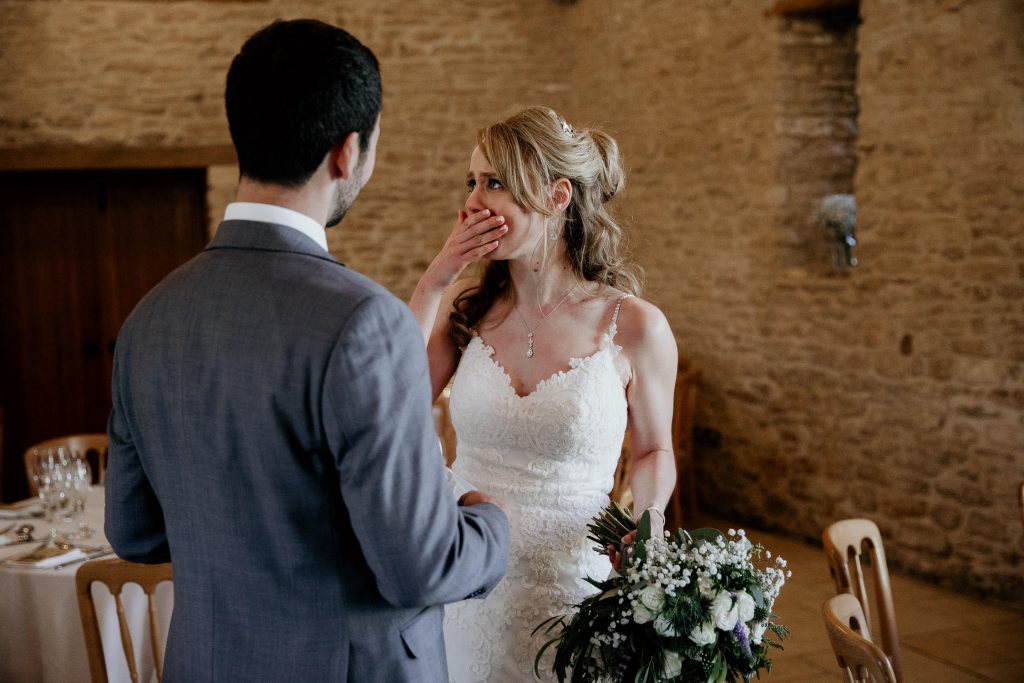 emotional photo of bride crying with groom in luxurious barn conversion wedding reception venue