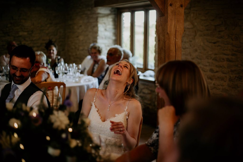 fun and relaxed poto of bride laughing along to wedding speeches