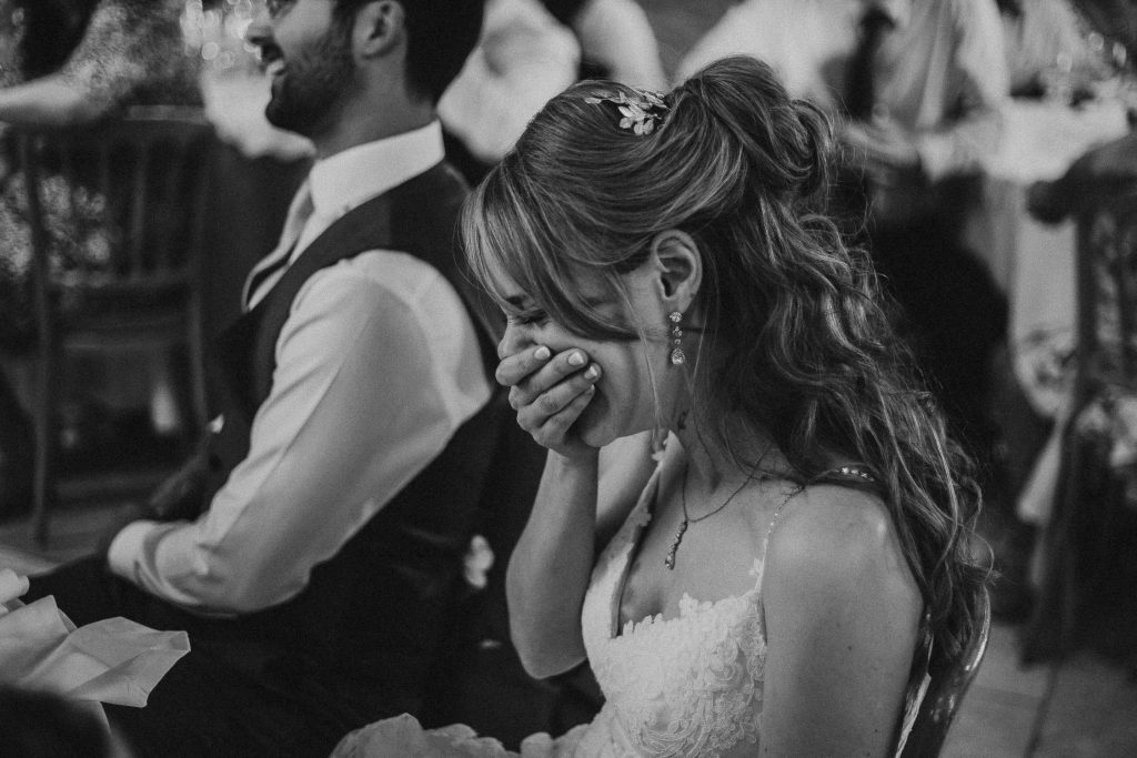 black and white photo of bride laughing during wedding speeches