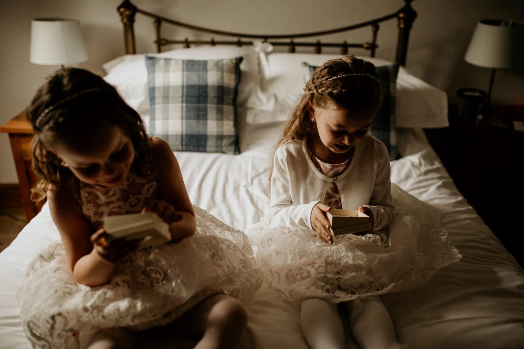 young smiling bridesmaids opening personalised gifts from bride on the morning of the wedding