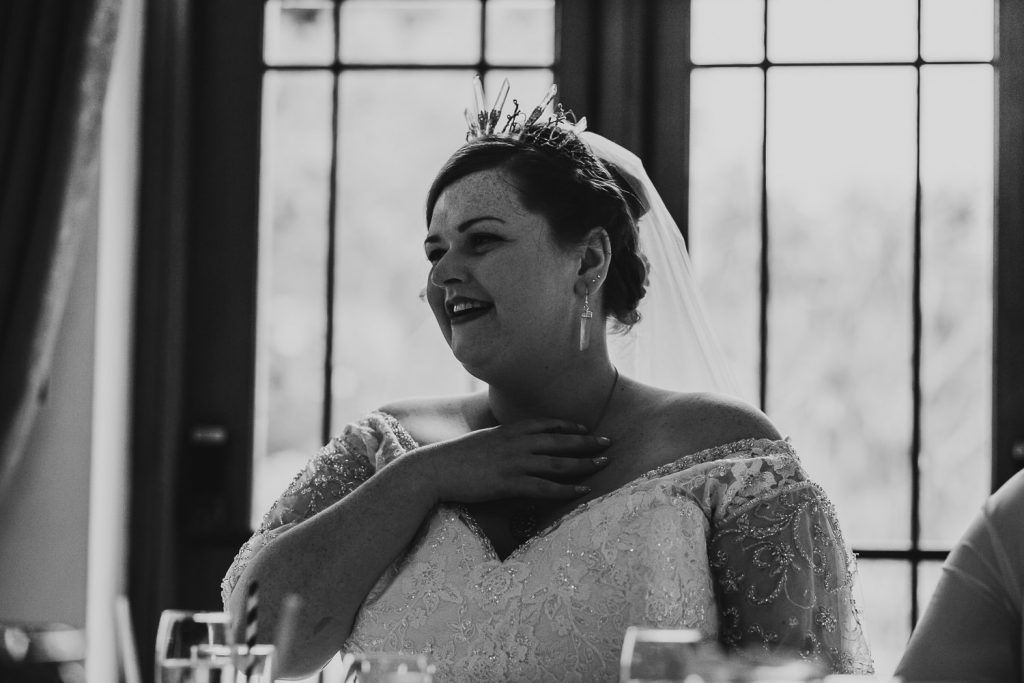 emotional black and white of bride listening to speeches