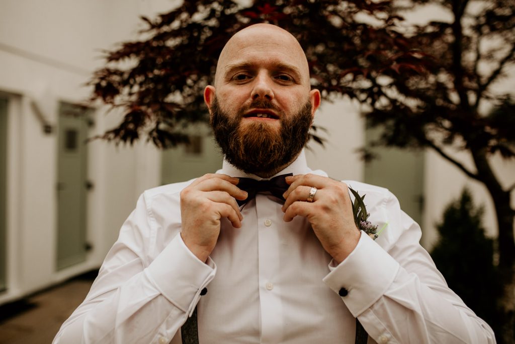 quirky alternative wedding groom fixes purple bow tie