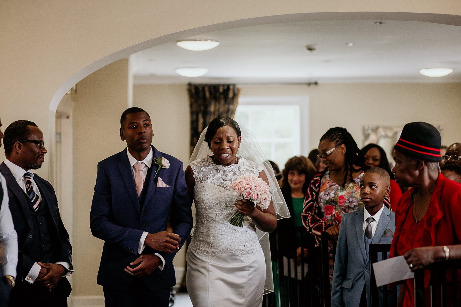 emotional photo of bride crying as she is walked down the aisle