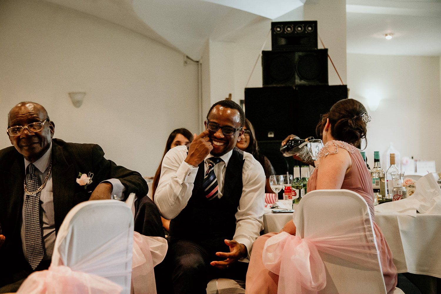 fun candid shot of wedding guest laughing and wiping away tears during the speeches
