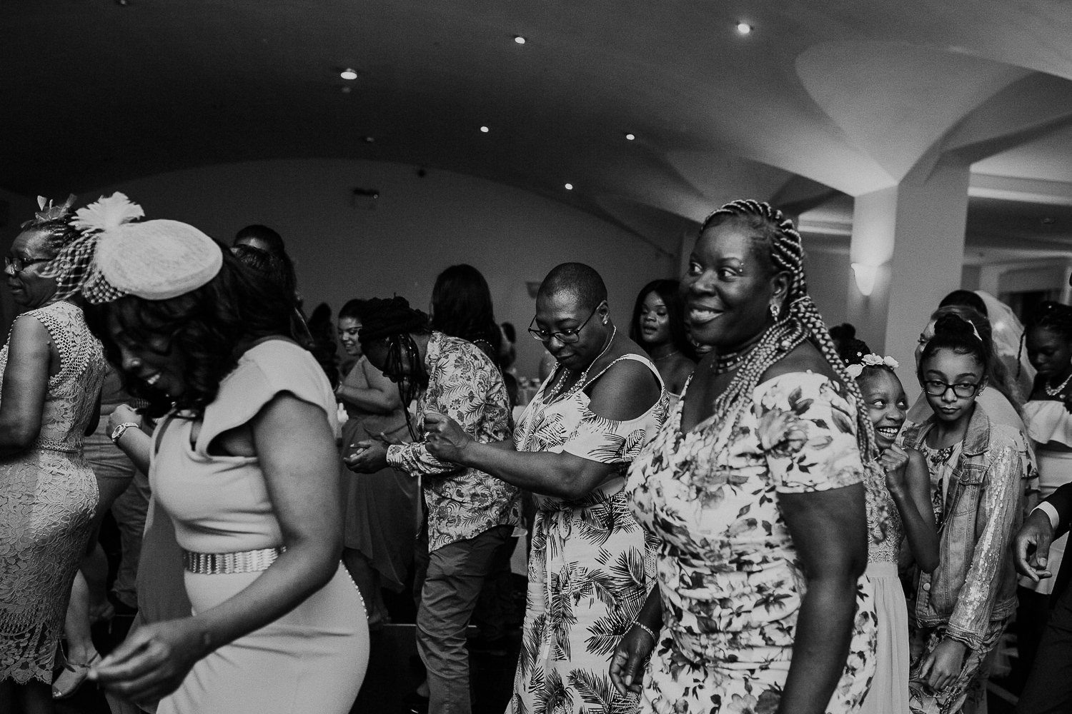 black and white photo showing wedding guests dancing on crowded dance floor