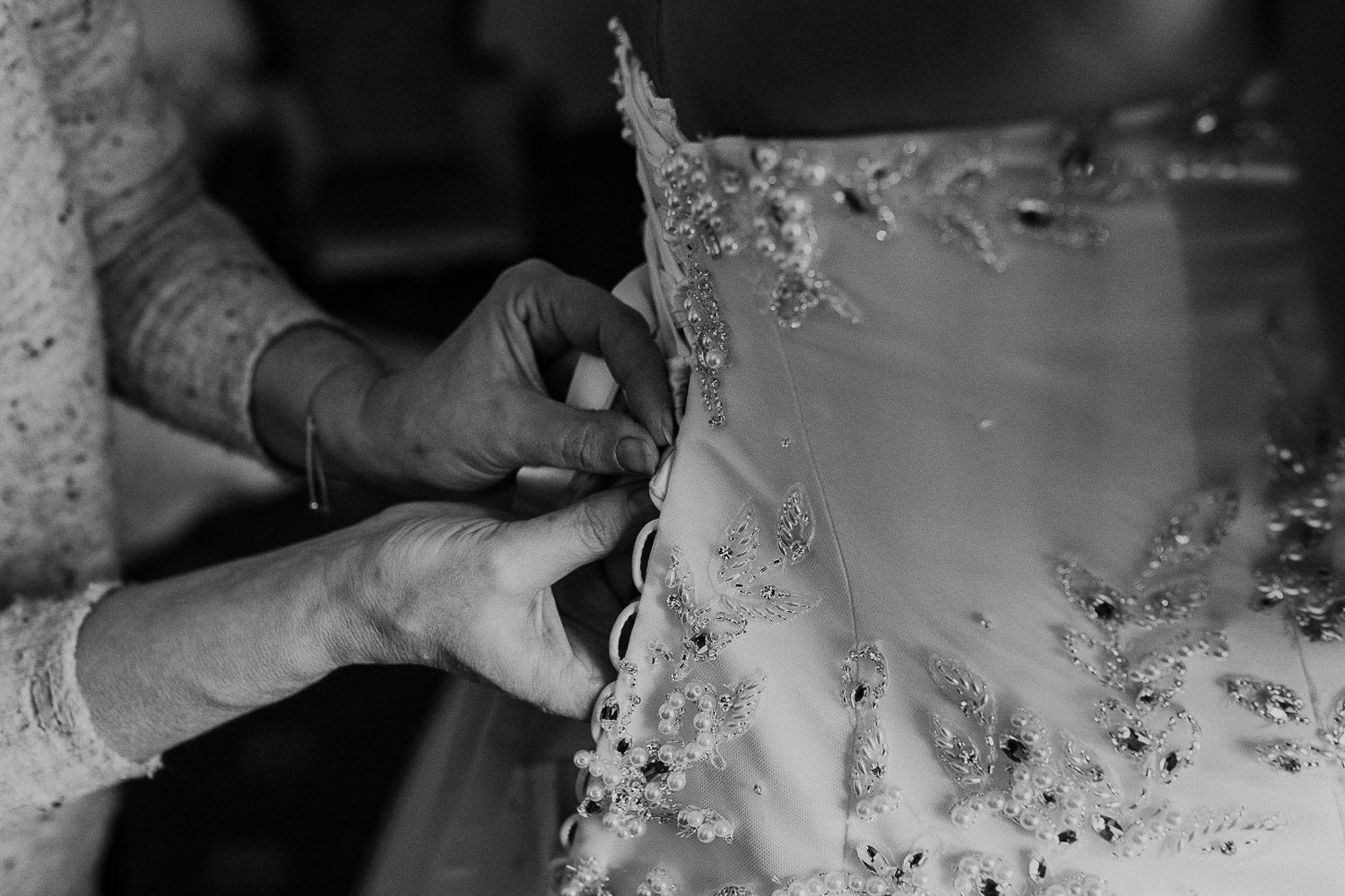 close up black and white photo of the brides dress being laced