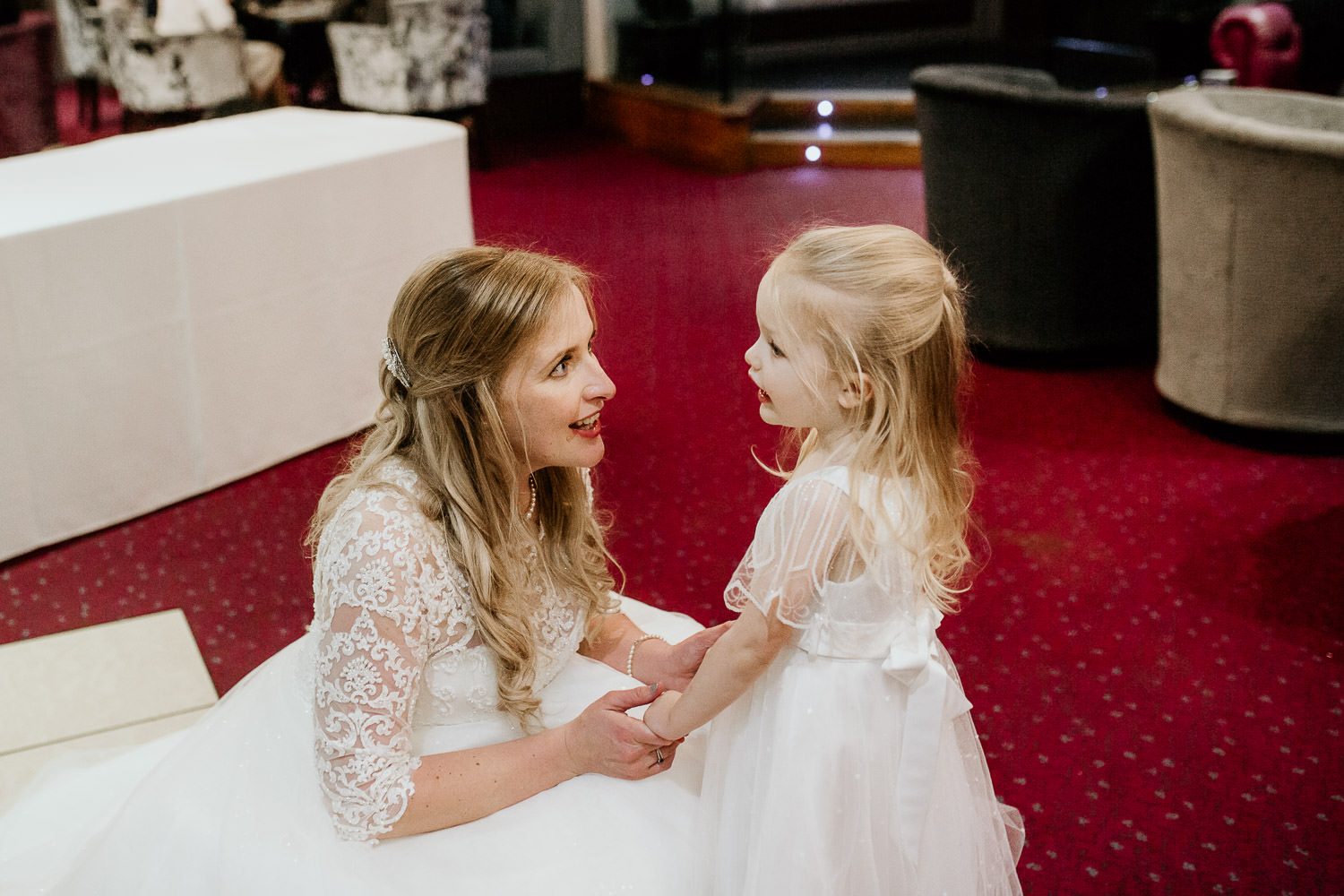 bride talking to flower girl during wedding reception in vale resort