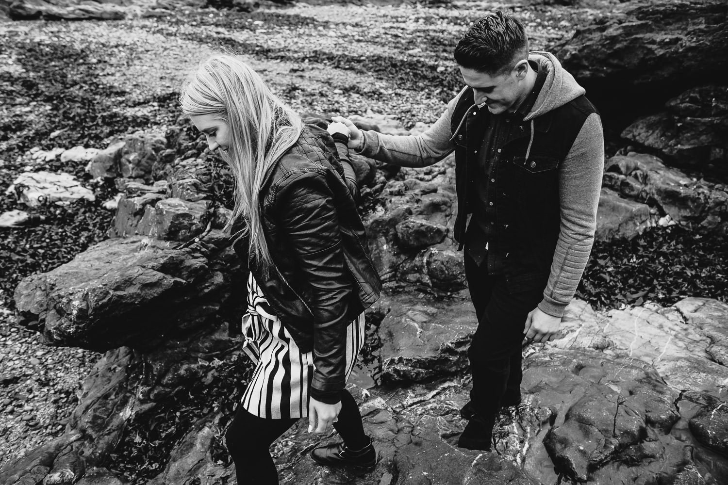 Bride and groom walk hand in hand seaside engagement shoot black and white