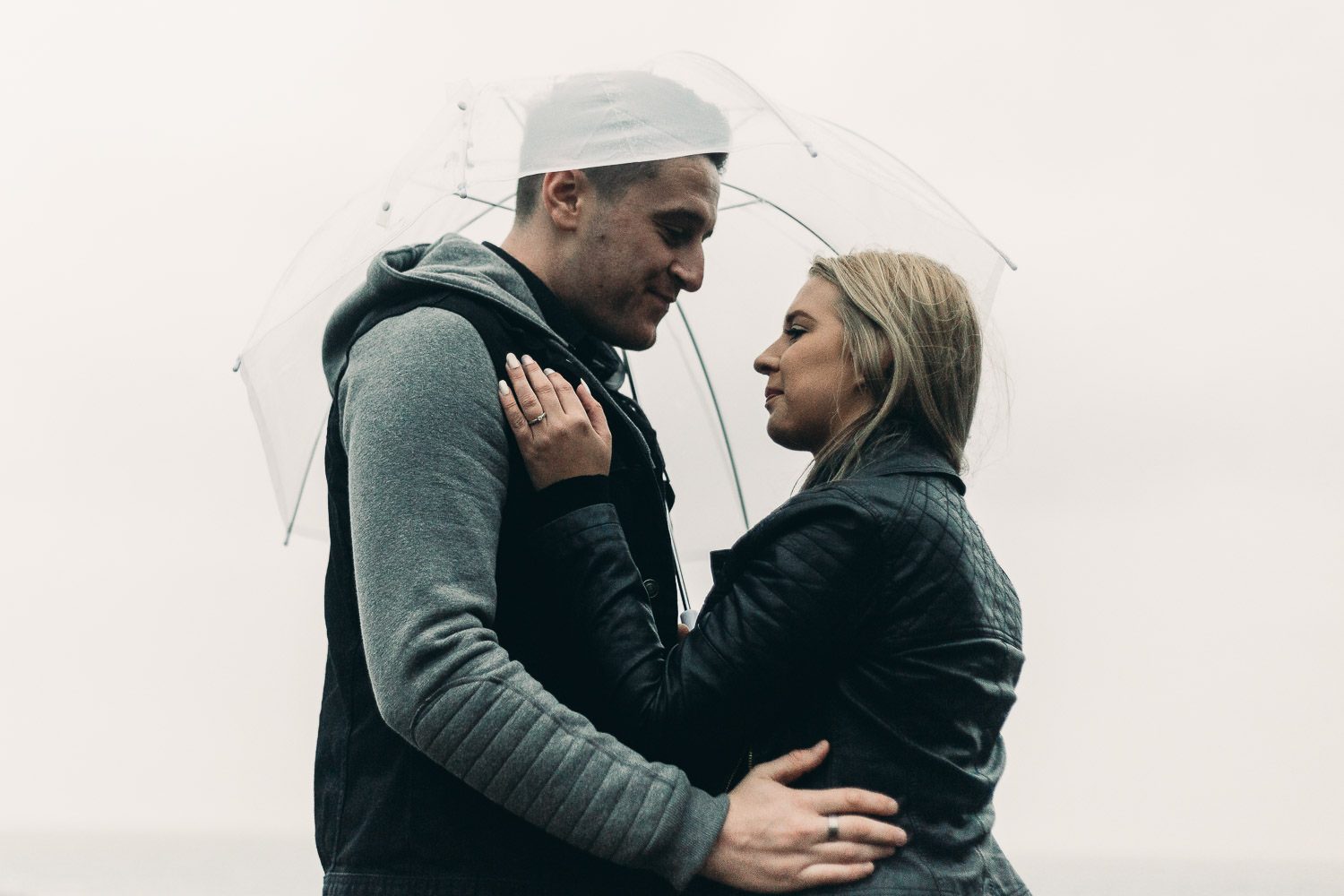 Bride and Groom under an umbrella on engagement shoot
