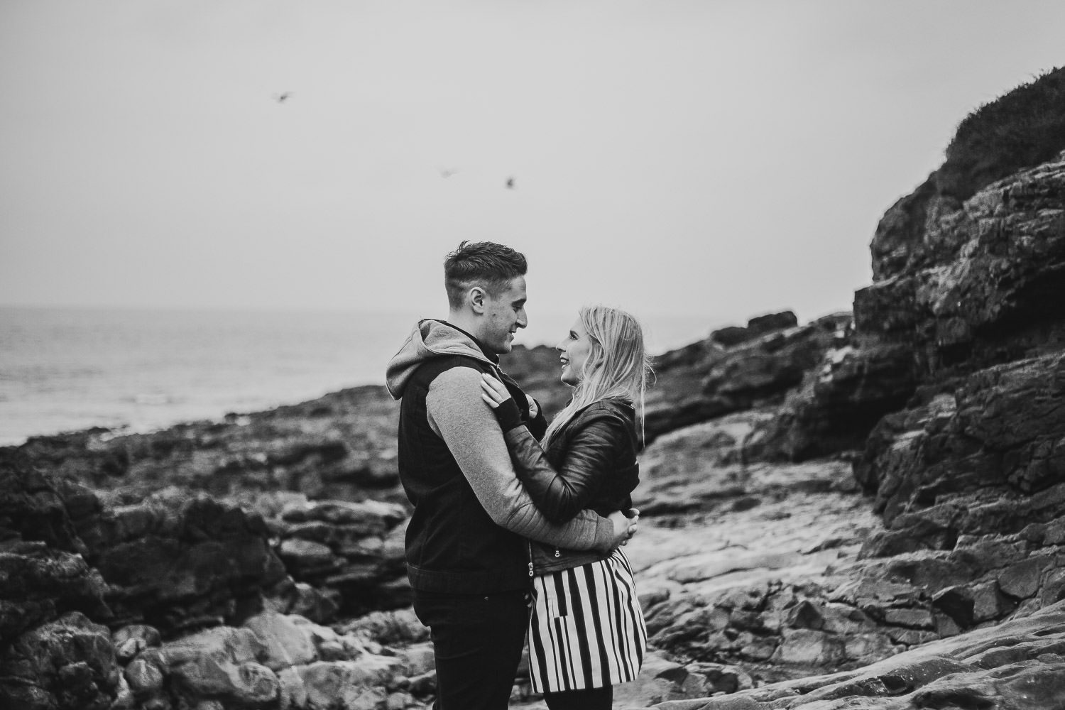 Black and white bride and groom laughing windy engagement shoot