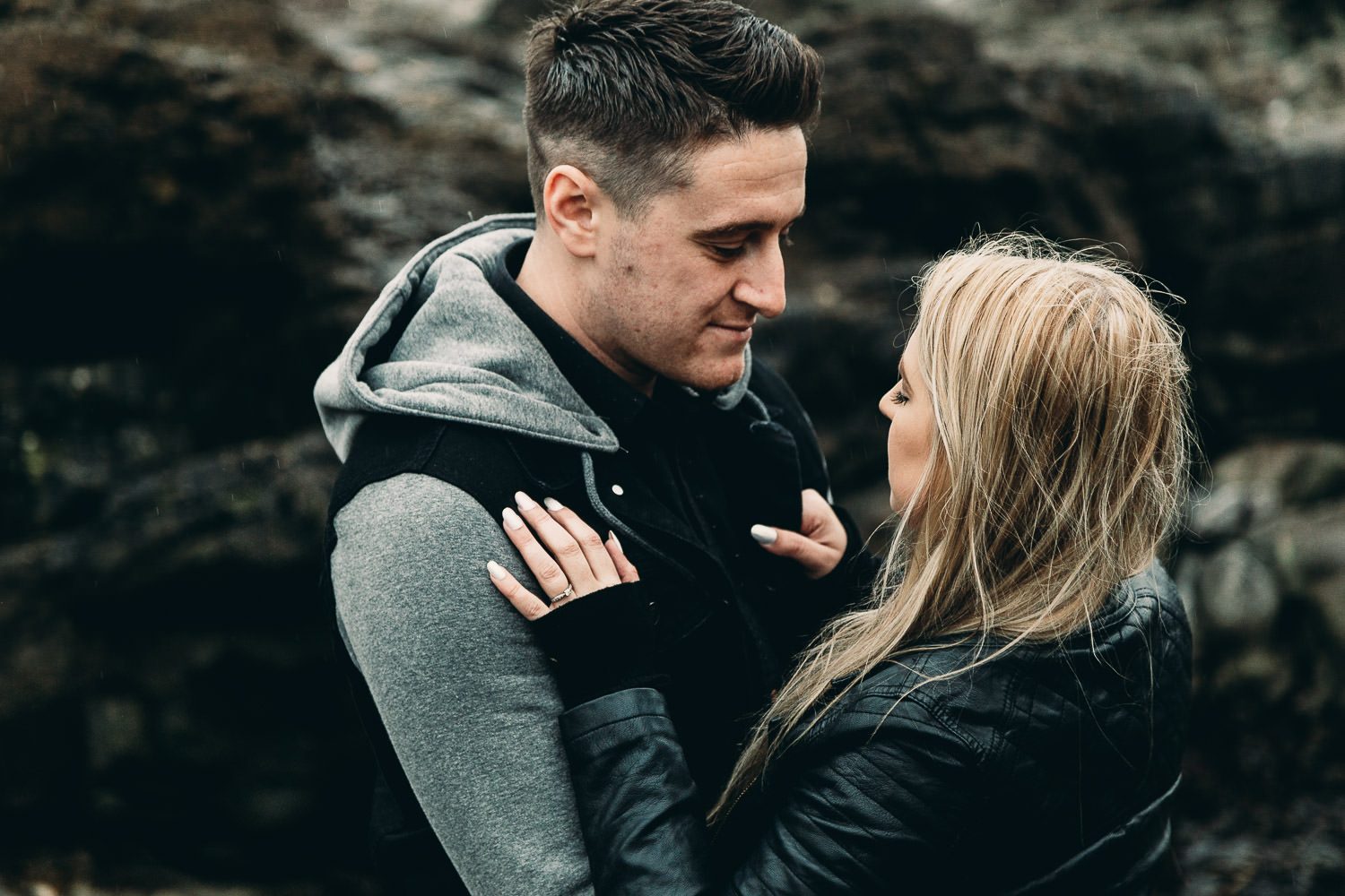 Bride and groom cuddle seaside engagement shoot