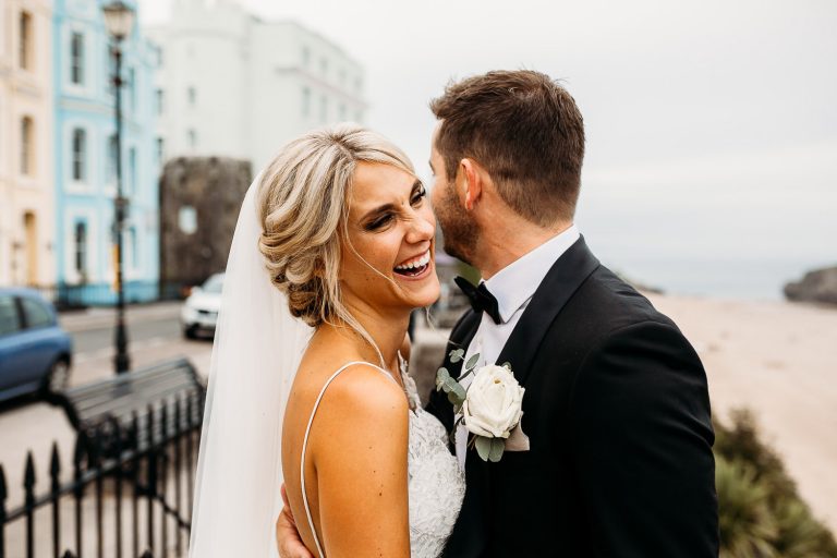 bride and groom laughing at tenby beach wedding