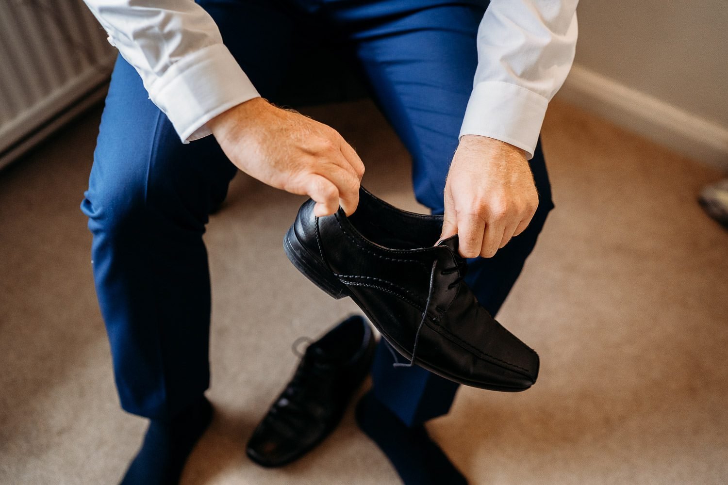 groom putting on shoes during groom preparations