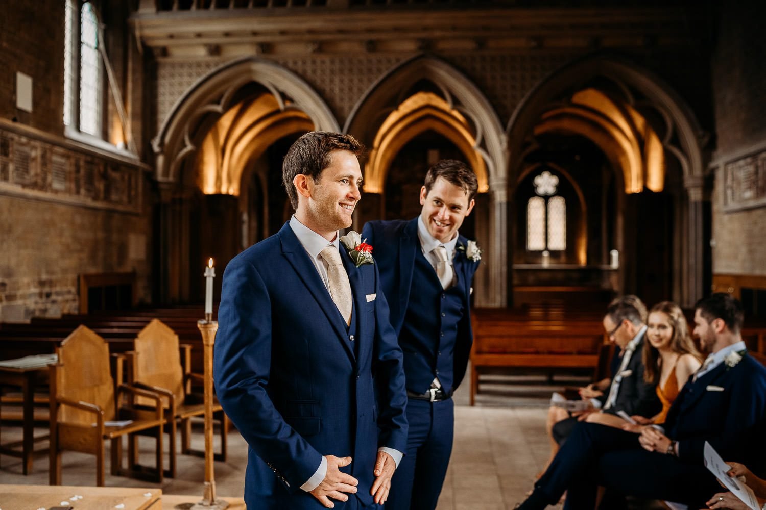 groom and brother smiling while waiting for bride at alter