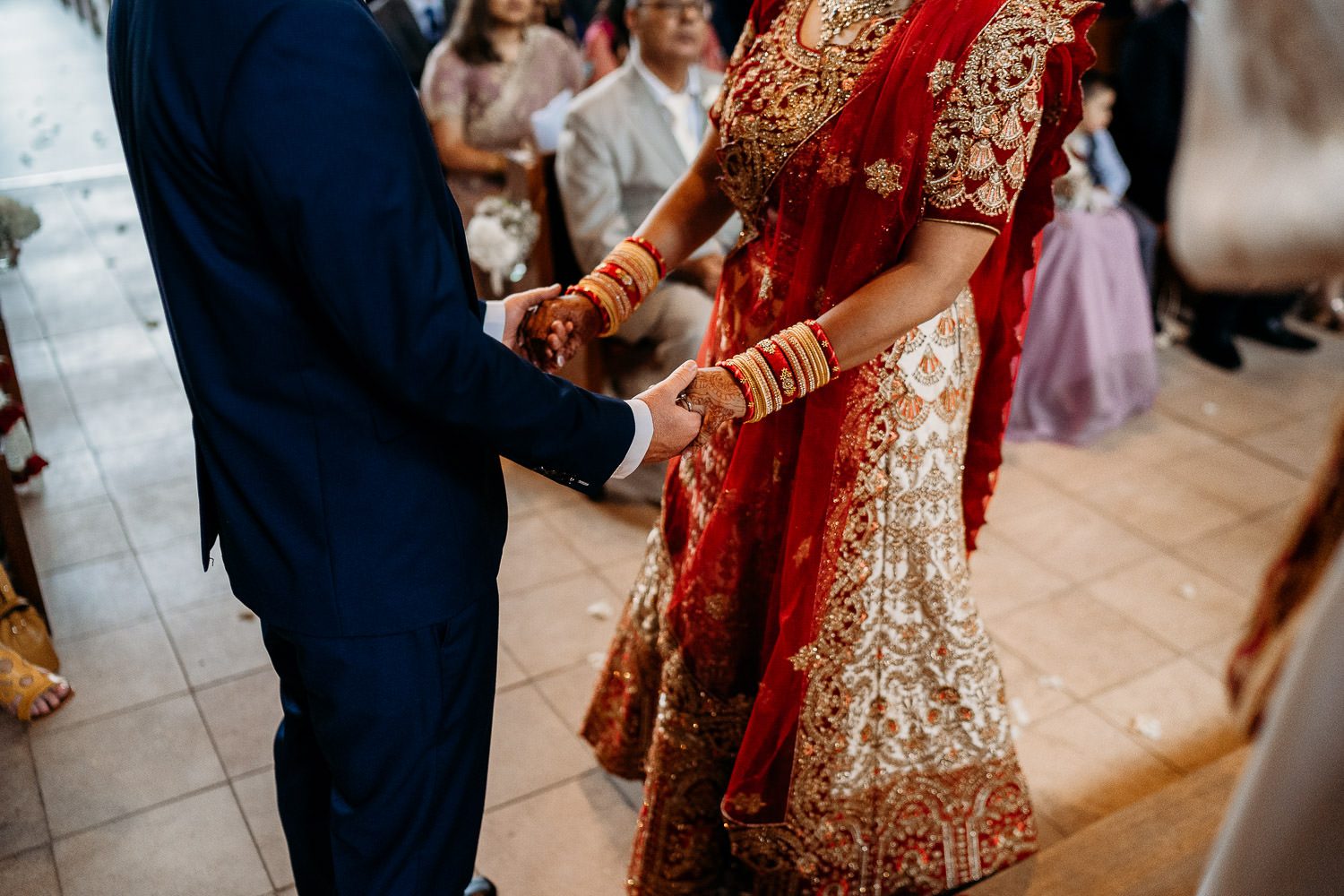 indian bride and groom holding hands during wedding ceremony
