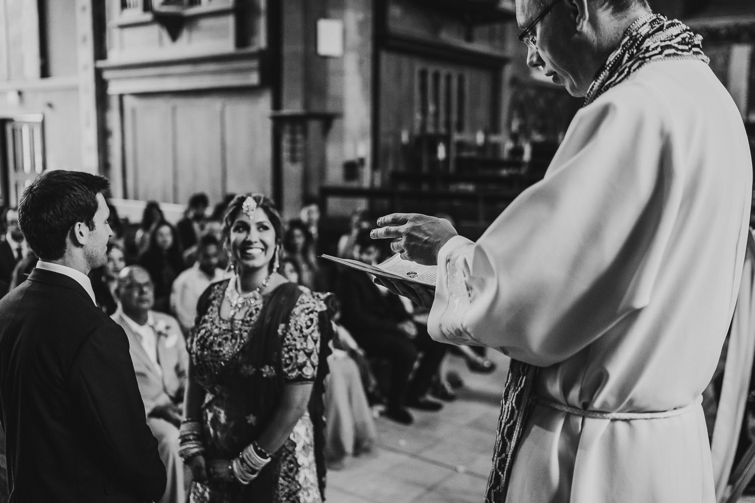 vicar blessing wedding rings during wedding ceremony in uppingham chapel