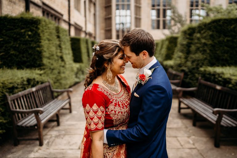 indian bride and groom smiling outside of uppingham chapel