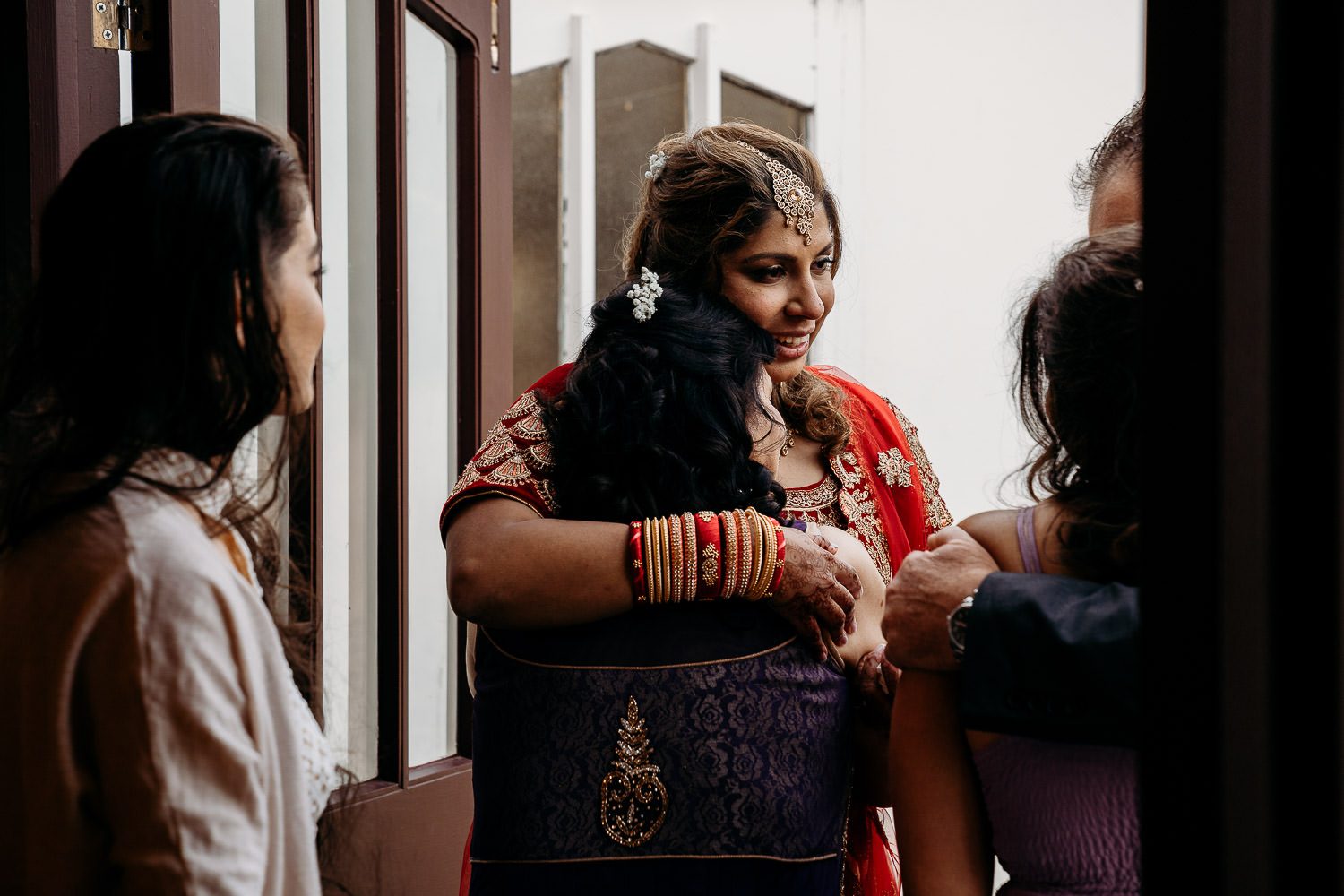 indian bride and mother hugging at wedding reception