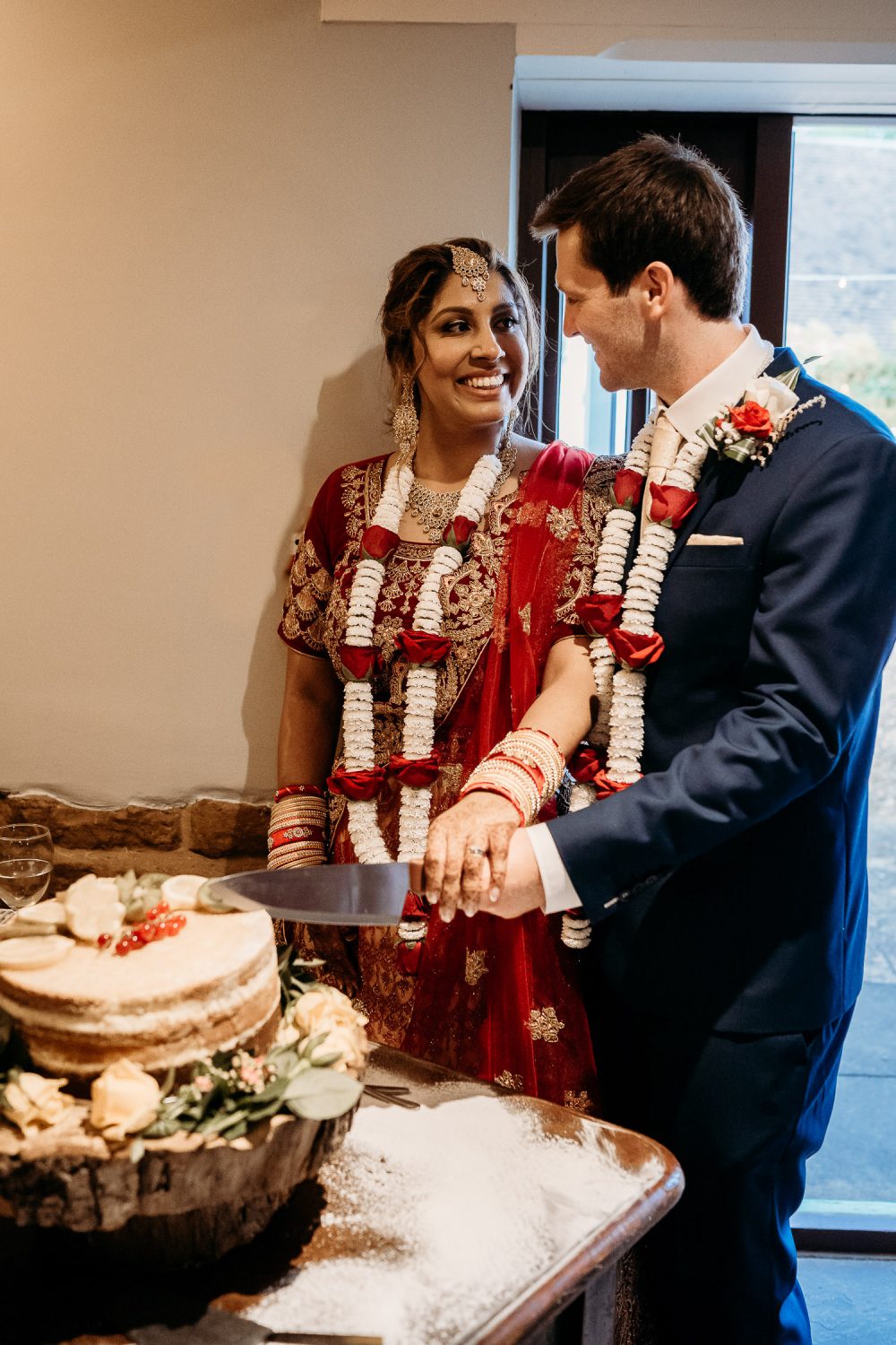asain bride and groom cutting their wedding cake