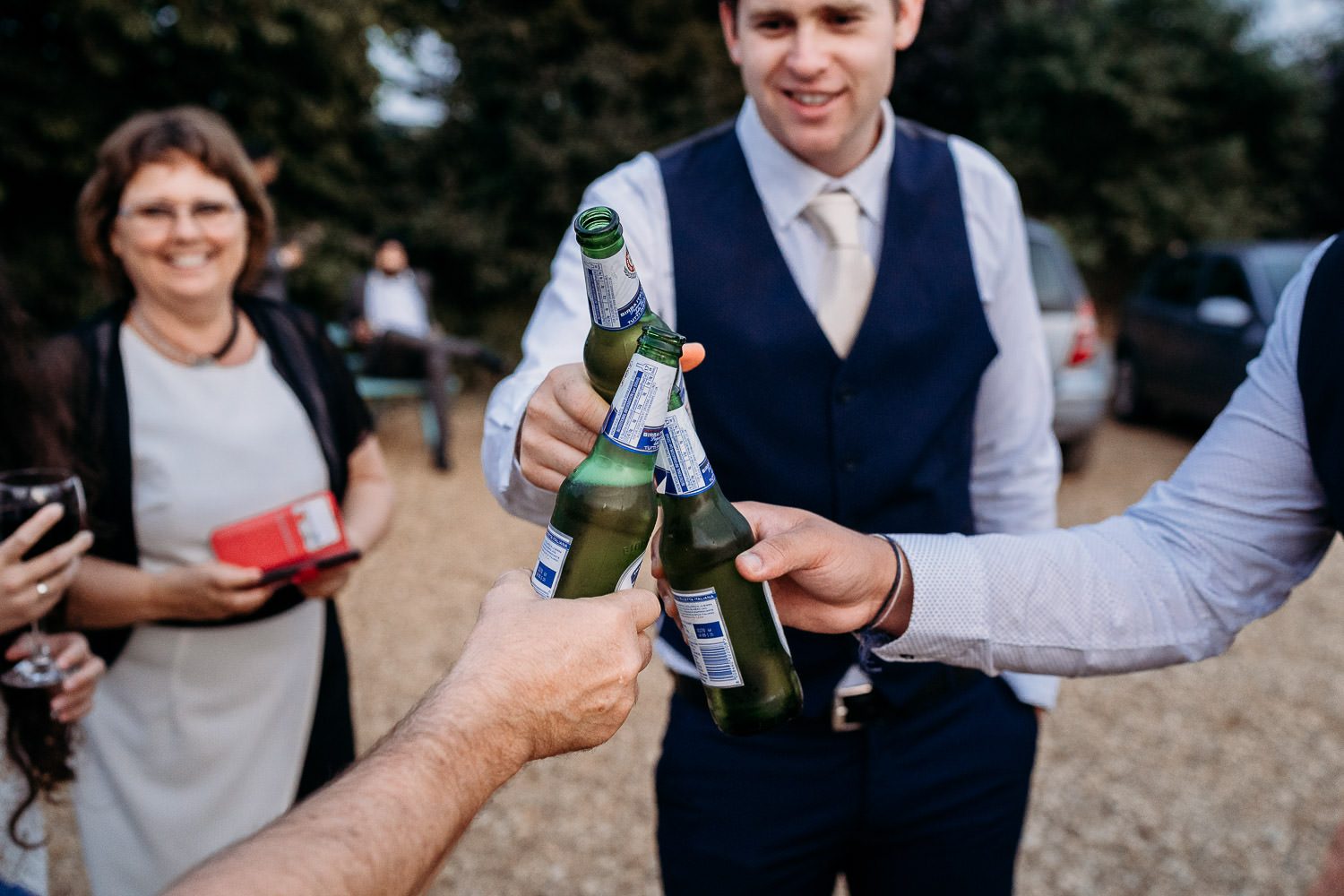 groom and groomsmen cheers with bottled beer