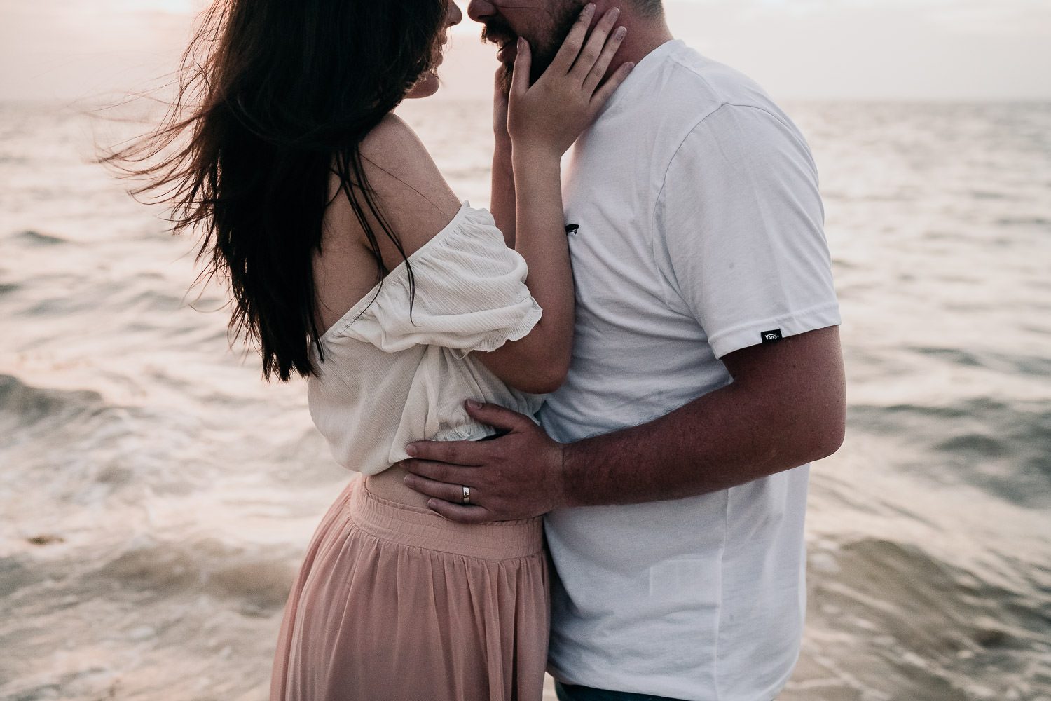 groom holding bride close at sunrise in cancun
