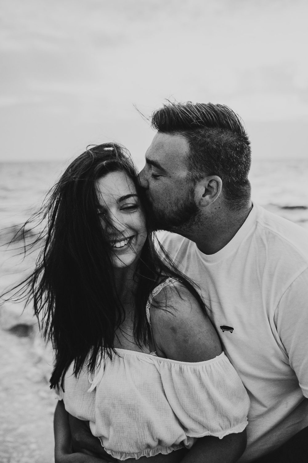 groom cuddling and kissing bride at sunrise in mexico