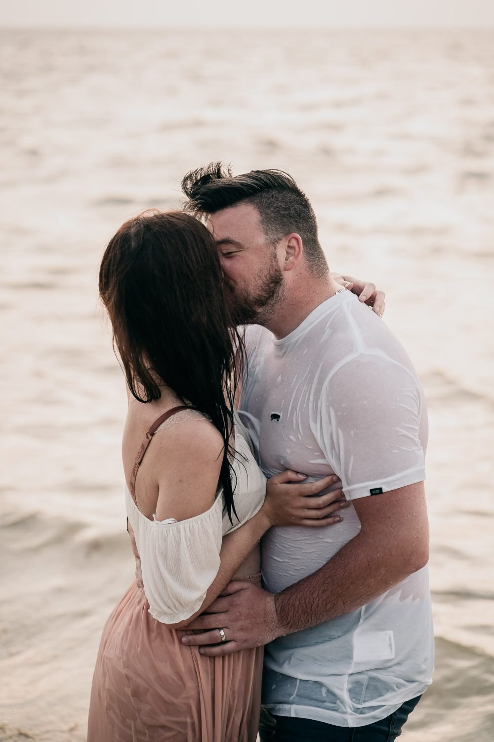 couple kissing on cancun beach at sunrise