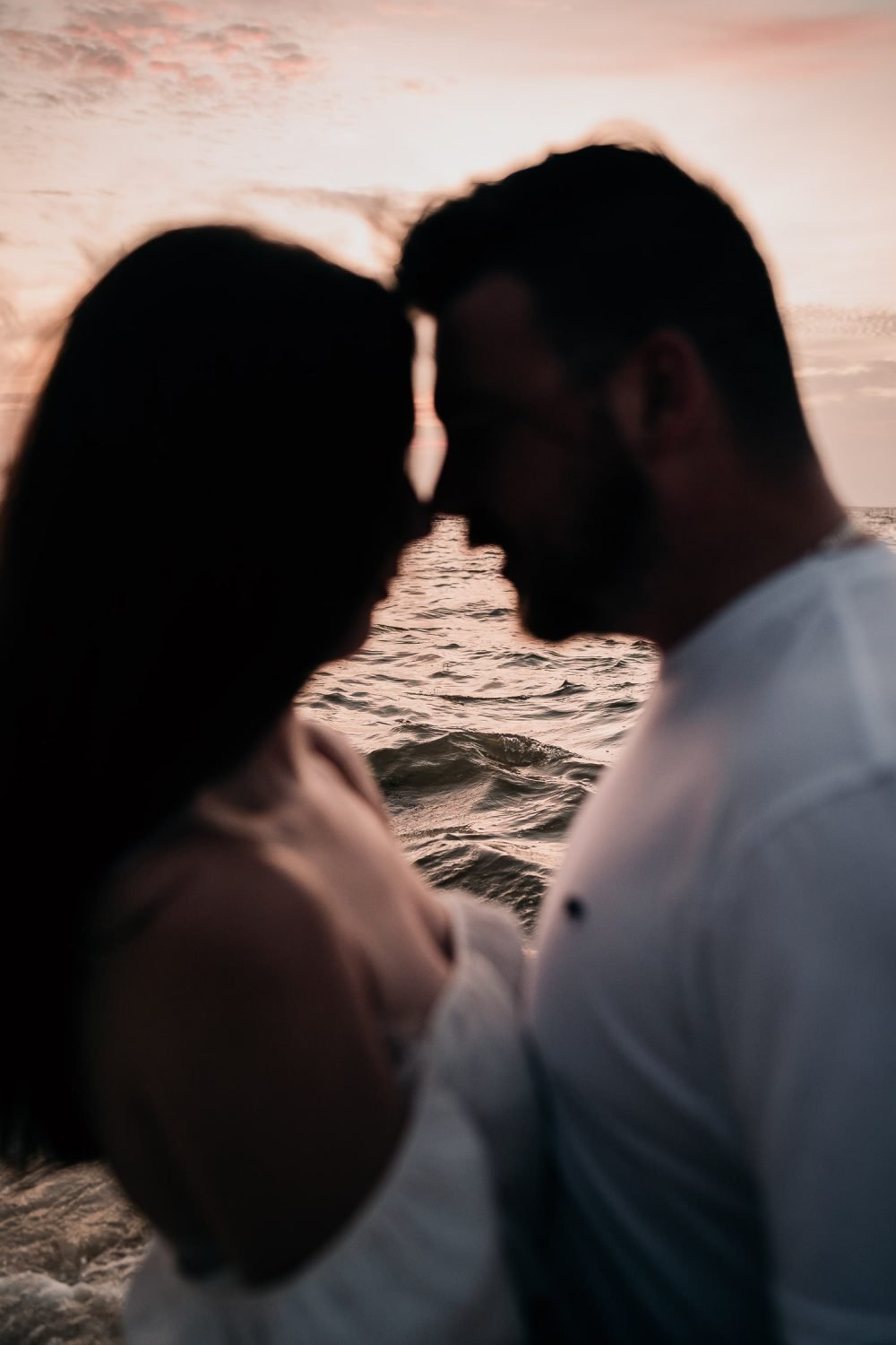 bride and groom holding each other at sunrise on mexico beach