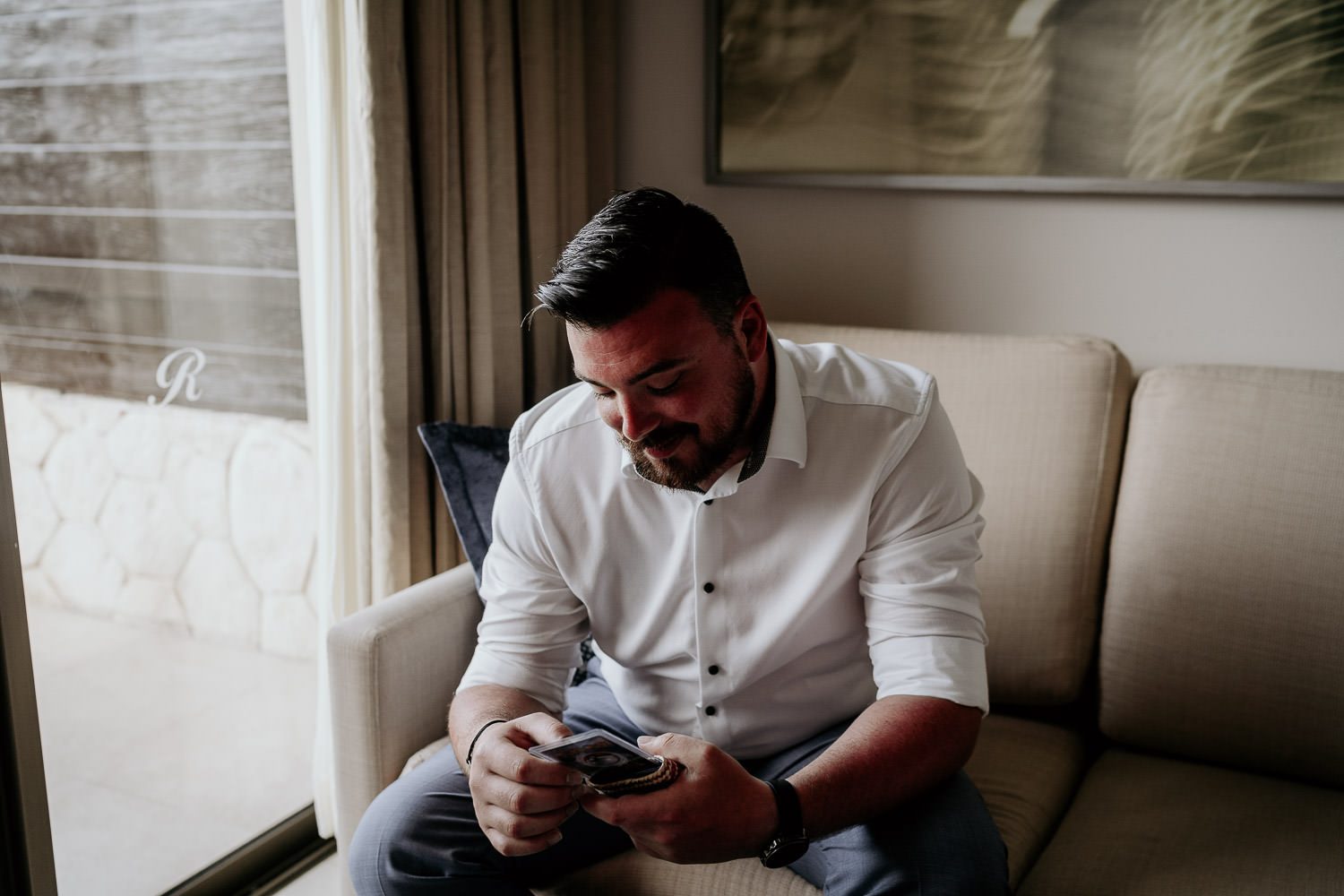emotional groom smiling at wedding gift from bride