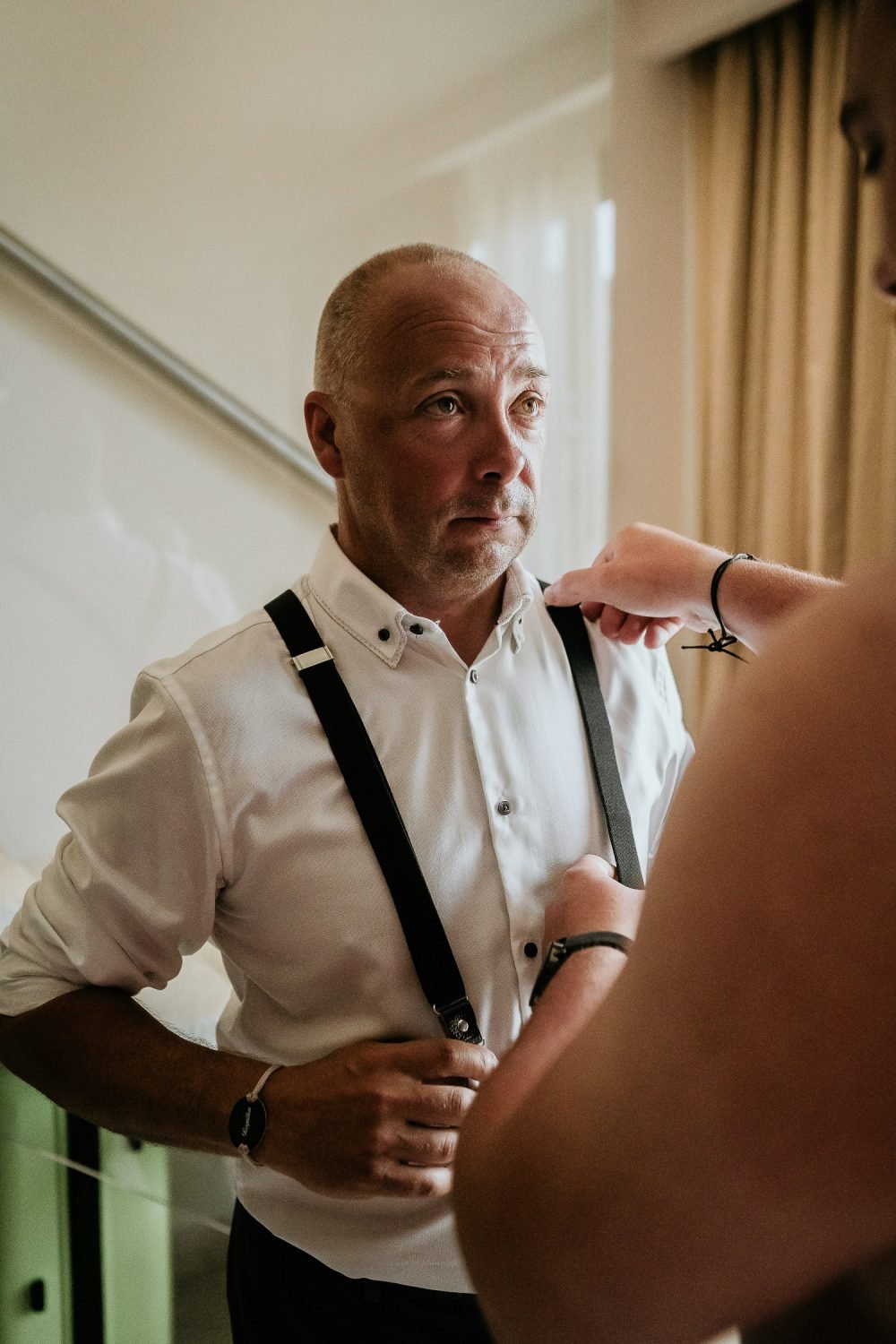 groom helping father of groom with braces for suit