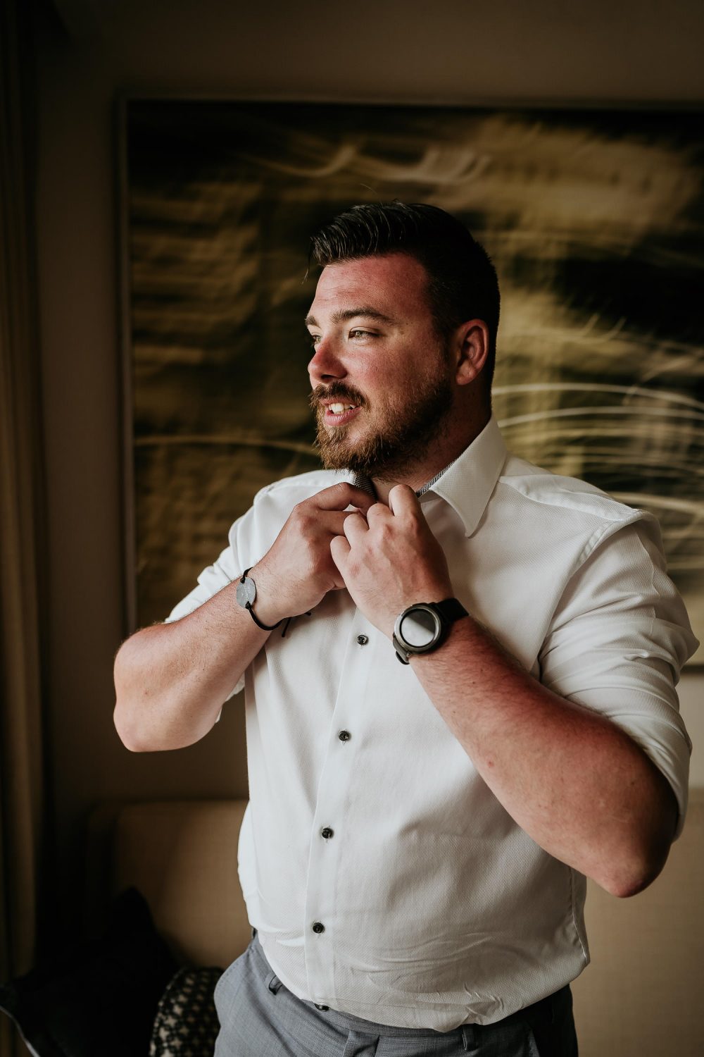 groom adjusting buttons on suit