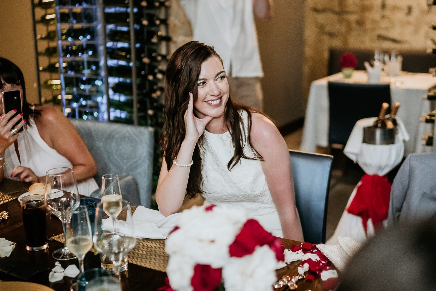 bride smiling at groom during wedding speech in cancun