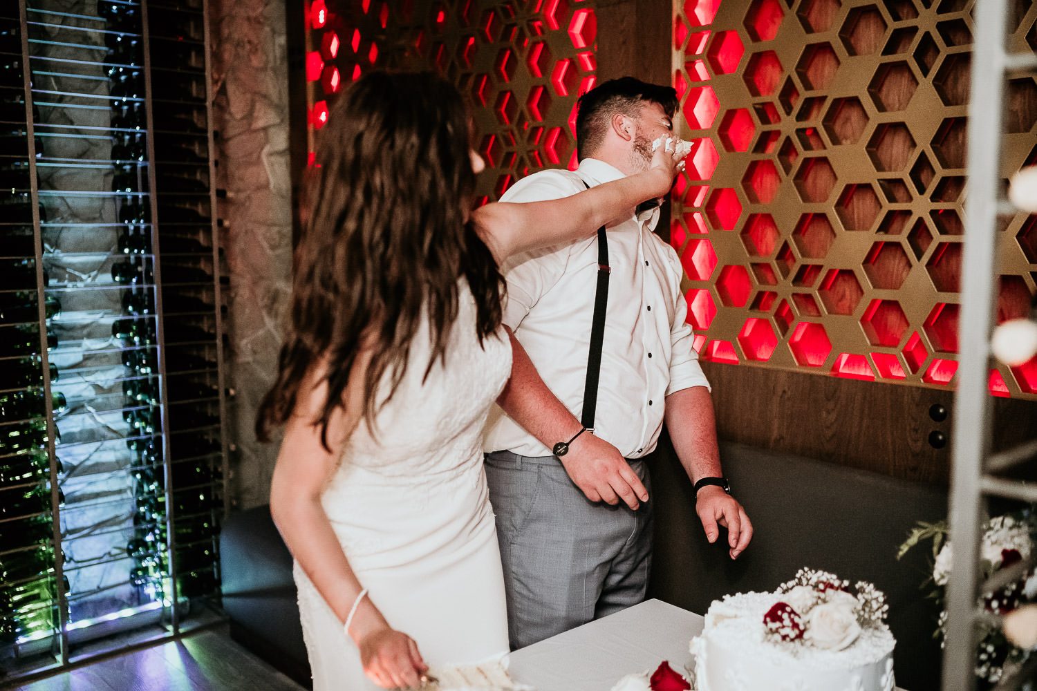 bride putting cake on grooms face in cancun