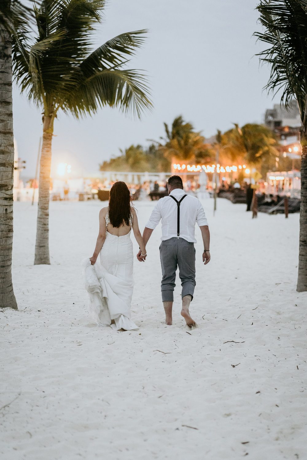 bride and groom walking on mexican beach