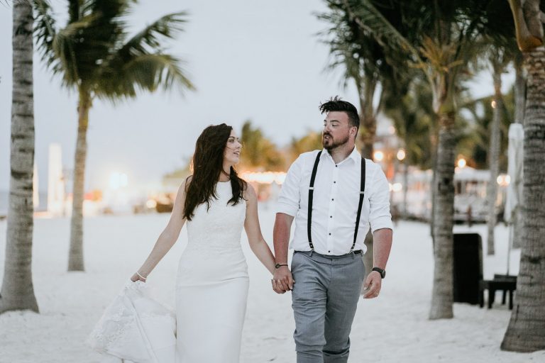 bride and groom walking on beach in cancun