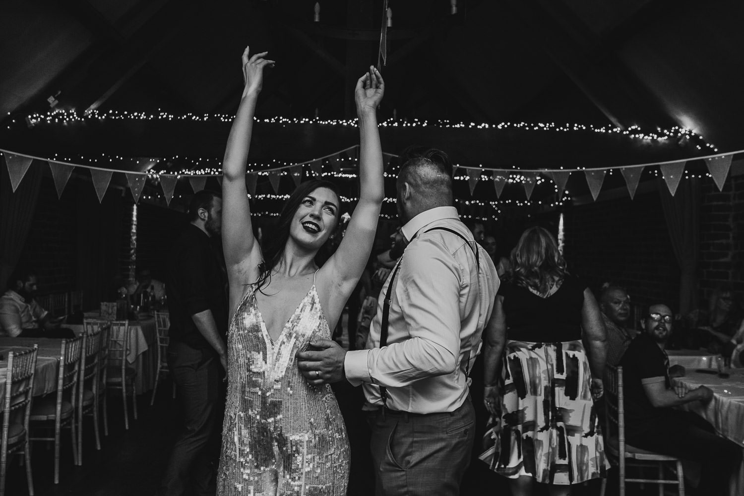 fun alternative bride in sequin jumpsuit dancing during wedding reception
