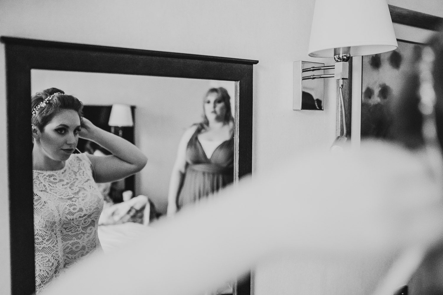 bride fixing her hair in mirror in mercure elcot hotel room
