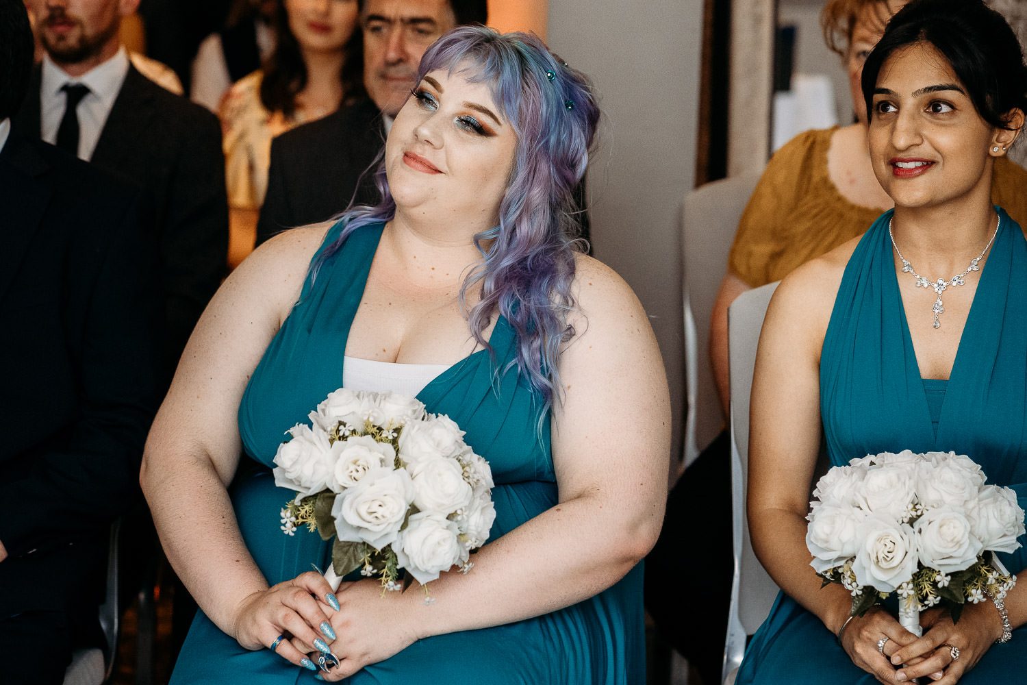 alternative bridesmaids smiling at wedding couple during ceremony