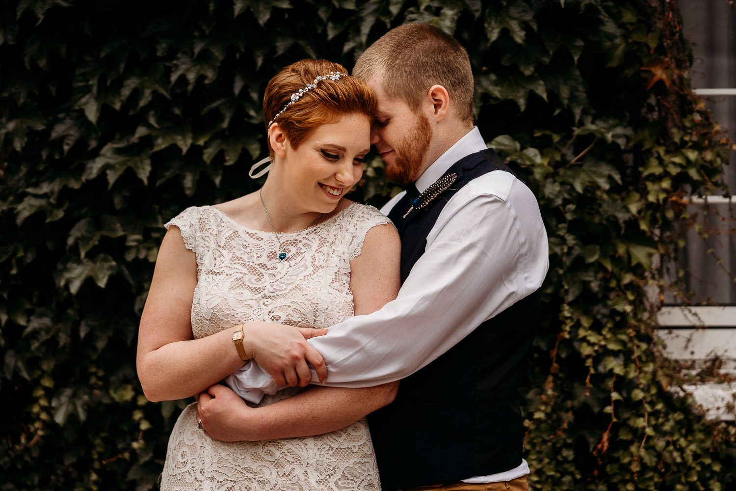 bride leaning on groom and smiling outside newbury hotel wedding venue