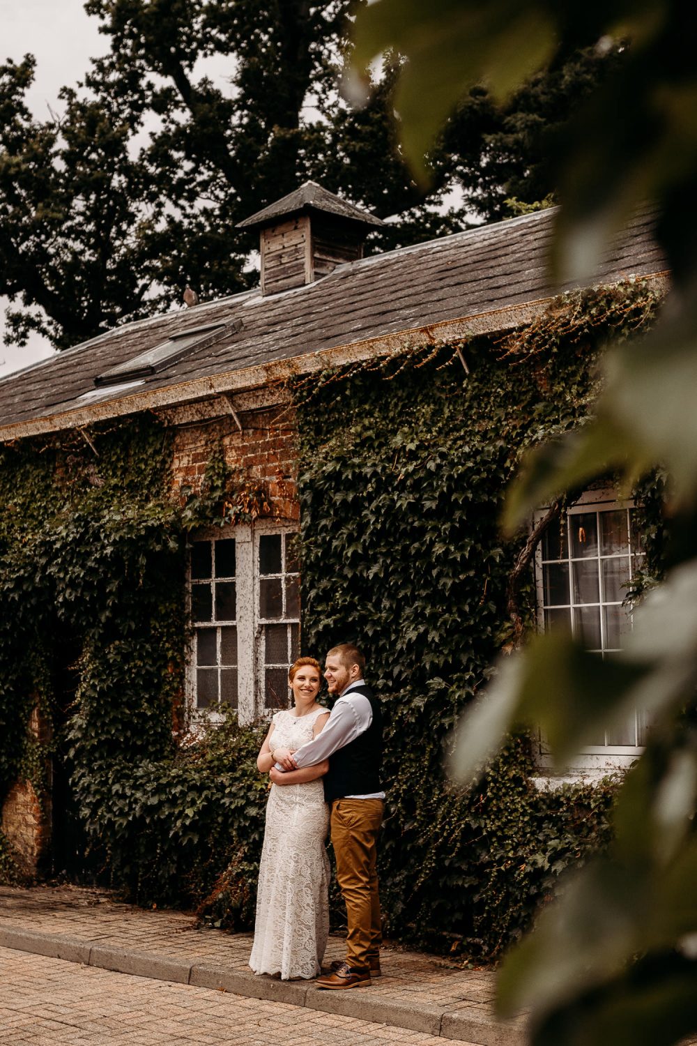 romantic bride and groom and smiling outside mercure hotel in newbury