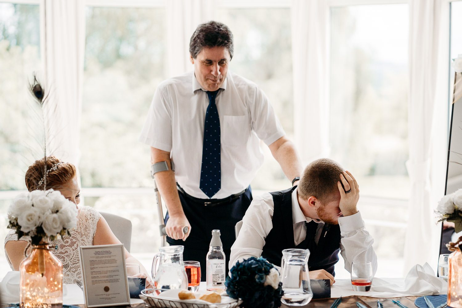 groom laughing during father of the bride's speech